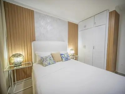 a bedroom with a large white bed with two pillows at Cozy 2br-2bt Apt Near The Beach And Main Street in Sosúa