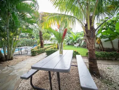 a park bench with a vase sitting on top of it at Cozy 2br-2bt Apt Near The Beach And Main Street in Sosúa