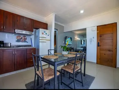 a kitchen with a table and chairs and a refrigerator at Cozy 2br-2bt Apt Near The Beach And Main Street in Sosúa