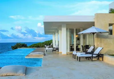a villa with a swimming pool next to the ocean at Cap el Limon Luxury Villas in El Limón