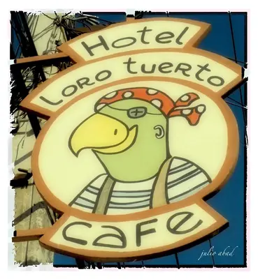 a sign with a chicken on the side of a store at Hotel Loro Tuerto in Santa Cruz de Barahona