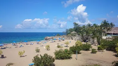 a beach with a lot of people and the ocean at Fully Equipped New 1br Apt dt 2mins To Beach in Sosúa