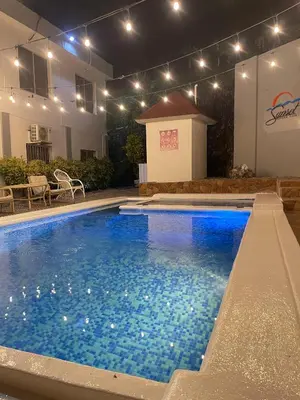 a swimming pool with blue water in front of a building at Casa Docia Hotel in Santa Bárbara de Samaná