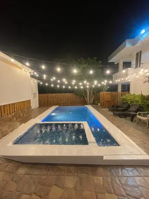 a swimming pool in a backyard at night with lights at Casa Docia Hotel in Santa Bárbara de Samaná