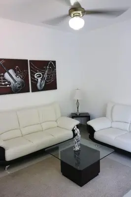 a living room with two white couches and a coffee table at Tu Segundo Hogar en Santiago, La Cuidad CORAZÓN in Santiago de los Caballeros