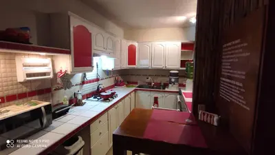 a kitchen with white cabinets and red accents at Private Rooms-Art Punta Cana in Punta Cana
