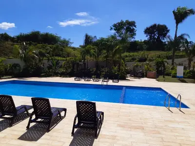 a swimming pool with four chairs and a swimming pool at Paraiso de verano in Santiago de los Caballeros