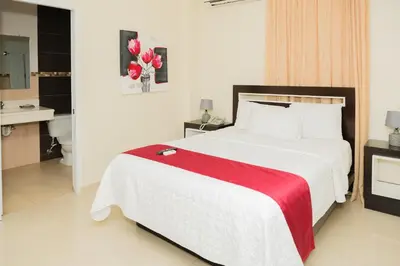 a bedroom with a large bed with a red blanket at Hostal San Francisco de Asis in Santo Domingo
