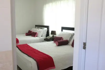 a bedroom with two beds with red and white sheets at Hostal San Francisco de Asis in Santo Domingo