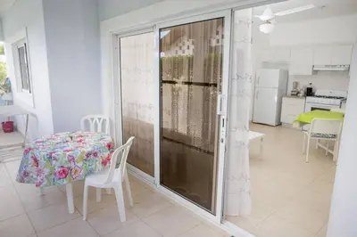 a room with a table and a table and a kitchen at Bela Villa Apartment IDA in Bayahibe