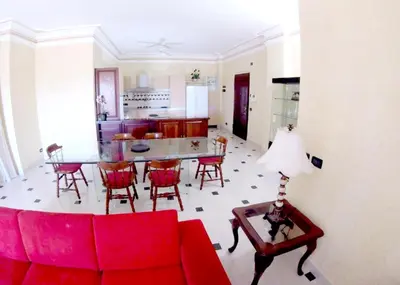 a living room with a red couch and a table at Modern Apartment in Boca Chica, 130 m², Air Conditioning Included in Boca Chica