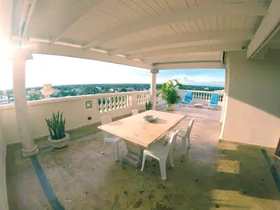 a patio with a table and chairs on a balcony at Elegant apartment with Jacuzzi in Boca Chica - 200 m² in Boca Chica