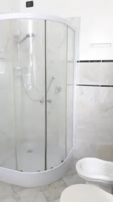 a white bathroom with a shower and a toilet at Elegant apartment with Jacuzzi in Boca Chica - 200 m² in Boca Chica