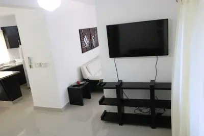 a living room with a flat screen tv on a wall at Apartamento Amueblado Amplio Tranquilo Privado Como tu lo Mereces in Santiago de los Caballeros
