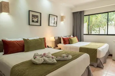 two beds in a hotel room with towels on them at Hotel Silvestre in La Romana