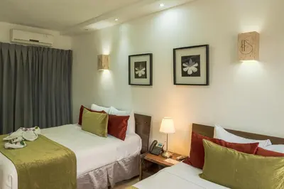 a hotel room with two beds and a couch at Hotel Silvestre in La Romana