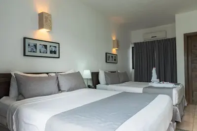 two beds in a hotel room with white at Hotel Silvestre in La Romana