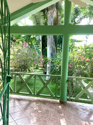 an open porch with a fence and flowers at La Cotica Casa Verde o Casa Azul in Las Terrenas