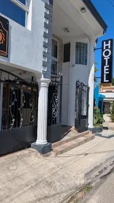 a white house with a black gate and stairs at Hotel Yamir in Santa Cruz de Barahona