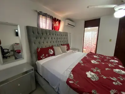 a bedroom with a large bed with a red comforter at Santo Domingo Paradise V - #211 in La Estrella