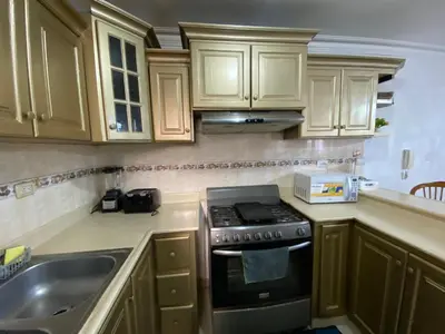 a kitchen with wooden cabinets and a stove and a sink at Santo Domingo Paradise V - #211 in La Estrella
