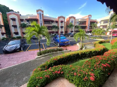 a parking lot with cars parked in front of a building at Santo Domingo Paradise V - #211 in La Estrella