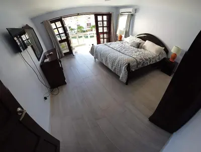 a bedroom with a bed and a wooden floor at Nanny Estates Cabarete kiters Condo C-6 in Cabarete
