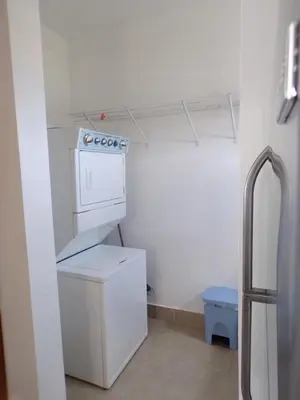 a small white kitchen with a washer and dryer at Luxury in the Caribbean in Sosúa