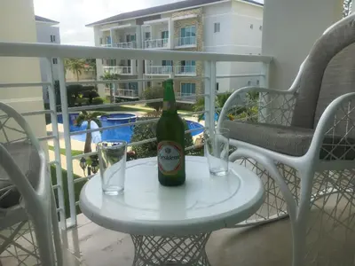 a bottle of beer sitting on a table on a balcony at Luxury in the Caribbean in Sosúa