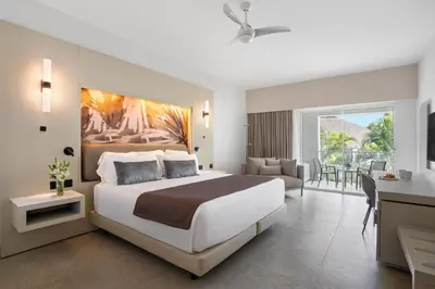 a bedroom with a large bed and a living room at Breathless Punta Cana Resort & Spa - Adults Only - All Inclusive in Punta Cana
