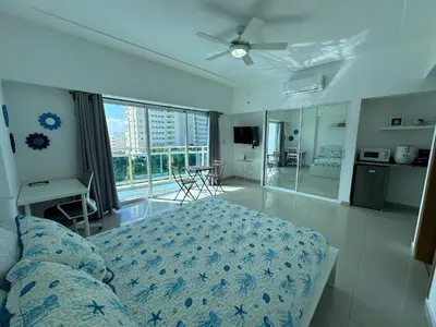 a bedroom with a bed and a living room with at Elegante Aqua Marine Apartamento Juan Dolio in Juan Dolio