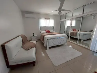 a bedroom with a bed and a chair and a mirror at 6-1 SANTIAGO CITY GREAT COZY APT TO STAY - Cozy 3 bedrooms Apartment for 7 peoples - close to all kind the business wifi - Air Condition in Santiago de los Caballeros
