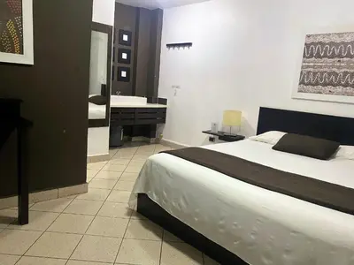 a bedroom with a bed and a bathroom with a sink at Ocean Breeze Studios in Santo Domingo