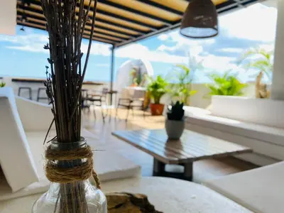 a vase with grass in it sitting on a table at Ocean Breeze Studios in Santo Domingo