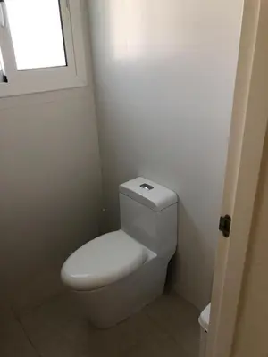 a white toilet in a bathroom with a window at Beautiful One Bedroom unit with pool and Beach club in a Golf Project in Punta Cana