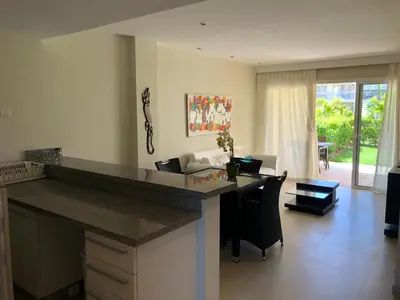 a kitchen with a counter top and a living room at Beautiful One Bedroom unit with pool and Beach club in a Golf Project in Punta Cana