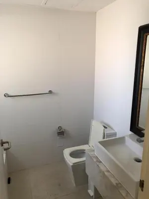 a white bathroom with a toilet and a sink at Beautiful One Bedroom unit with pool and Beach club in a Golf Project in Punta Cana