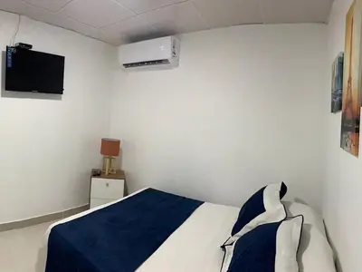 a bedroom with a bed and a air conditioner at Cozy Private Room in El Malecn, Santo Domingo in Santo Domingo