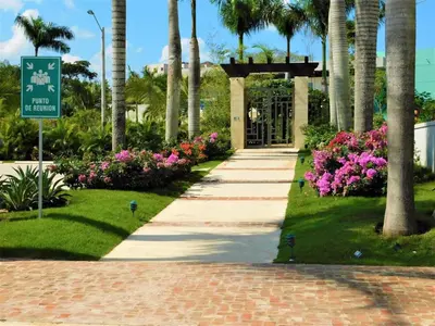 a walkway through a park with flowers and palm trees at Verano 2019 in Santiago de los Caballeros