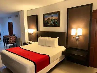 a hotel room with a bed with a red blanket at Ramada by Wyndham Princess Santo Domingo in Santo Domingo