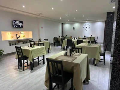 a restaurant with tables and chairs with green table cloth at Ramada by Wyndham Princess Santo Domingo in Santo Domingo