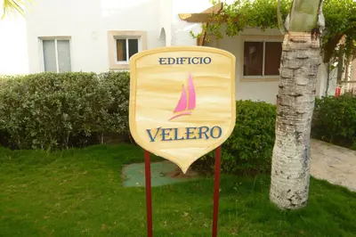 a sign in the grass in front of a house at The blue lagoon of the Caribbean Sea. Velero 205.Cadaques Caribe in La Fragata