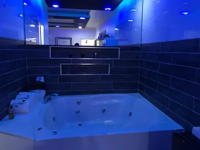 a large bath tub in a bathroom with blue lights at Hotel Rey in Concepción de La Vega