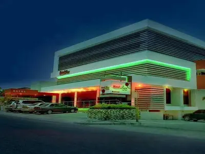a gas station with cars parked in a parking lot at Hotel Rey in Concepción de La Vega