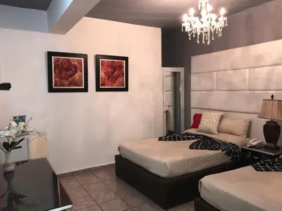a bedroom with two beds and a chandelier at Hotel Rey in Concepción de La Vega