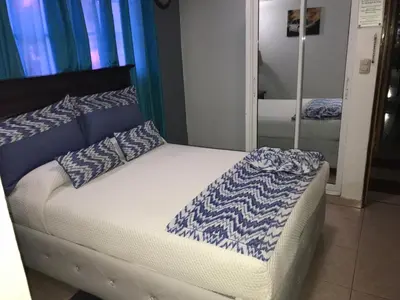 a bed with blue and white sheets and pillows at Hotel Rey in Concepción de La Vega