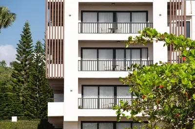 a white building with black windows and trees at Camp David Ranch in Santiago de los Caballeros