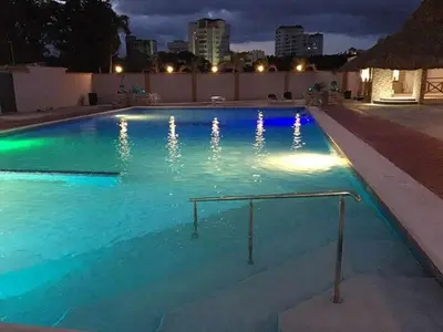 a swimming pool lit up at night at Matum Hotel & Casino in Santiago de los Caballeros