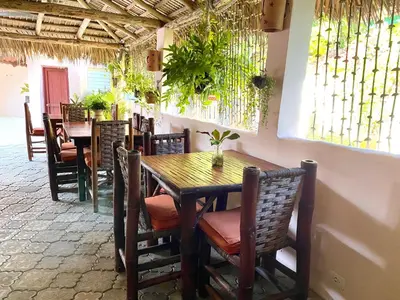a dining room with a wooden table and chairs at Hotel Alegria in Cabarete
