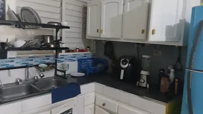 a kitchen with white cabinets and a sink at Recycled house in Santo Domingo